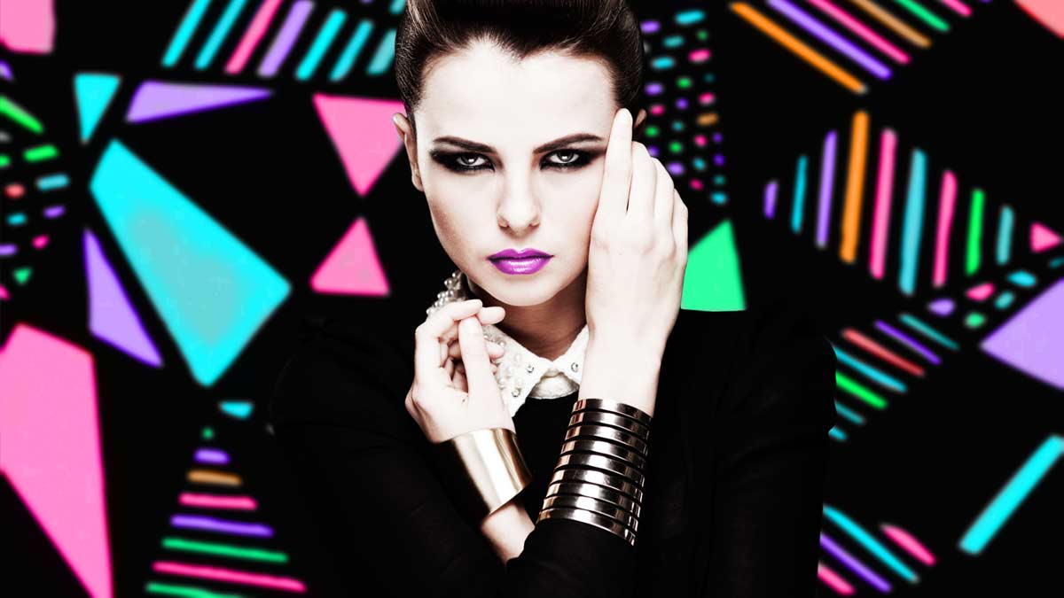 A woman with bright makeup and jewelry on her wrist.