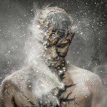 A man with a face covered in smoke and dust.
